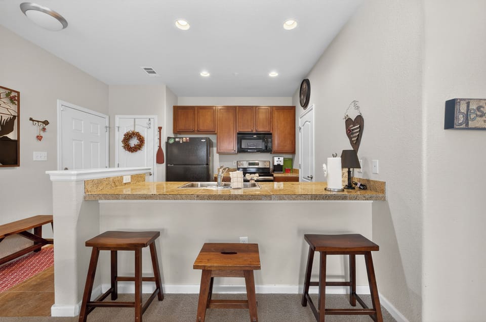 Gather at the breakfast bar to plan your day's adventures. A fully-equipped kitchen with granite counters awaits your culinary creations.