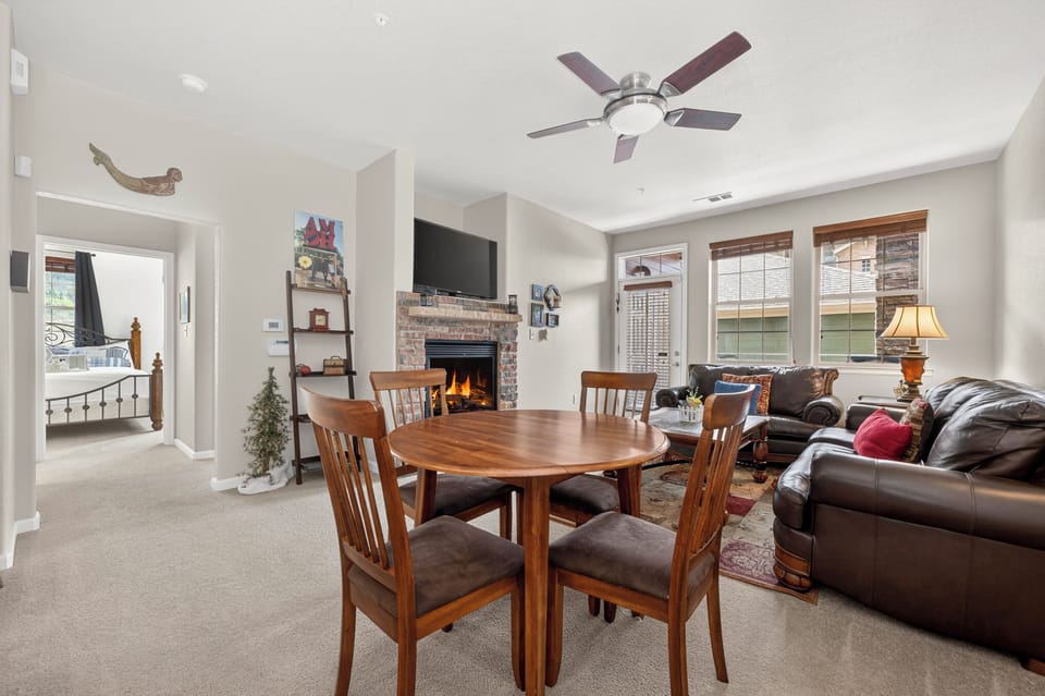Gather around the warm fireplace in this spacious living area, perfect for cozy meals and relaxing evenings with family and friends in your home away from home.