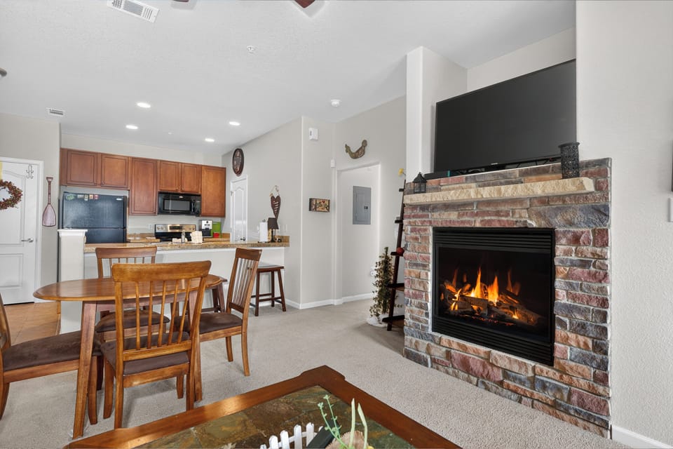 You'll love gathering around the cozy brick fireplace, sharing meals at the wooden dining table, and preparing your favorite dishes in the fully equipped kitchen with modern appliances.