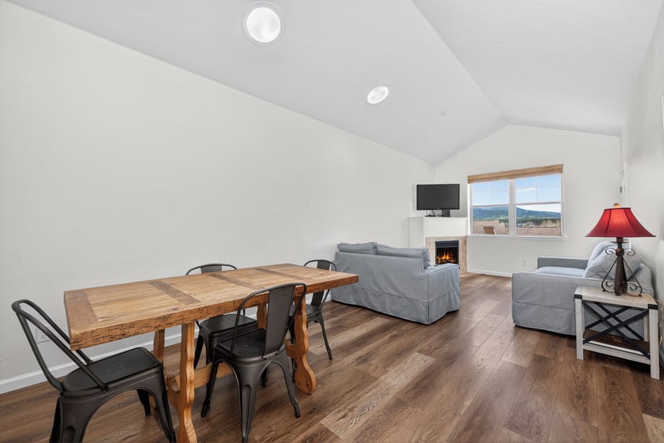Gather around the rustic dining table for family meals, or curl up by the flickering fireplace as natural light pours through the window revealing mountain views beyond.
