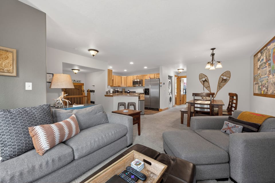 Unwind in your spacious open-concept living area, where plush seating, mountain-inspired décor, and a fully equipped kitchen create the perfect home base for your getaway.