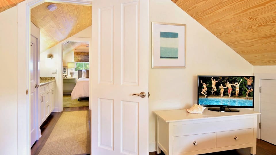 Settle into your private retreat where vaulted wood ceilings and coastal artwork create a warm, welcoming atmosphere—complete with a flat-screen TV for cozy evenings after beach adventures.