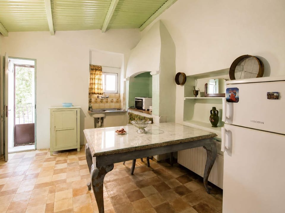 A charming kitchen featuring traditional architectural elements, exposed details, and a warm rustic aesthetic. The open layout and natural materials create a welcoming environment perfect for cooking meals