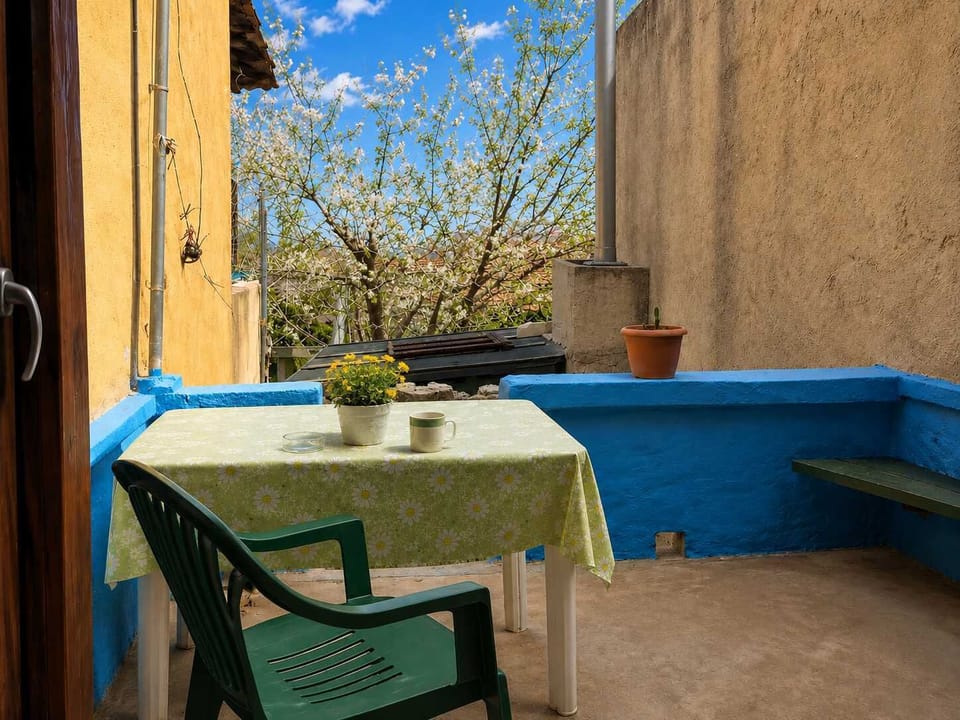 A cozy terrace with blue accents, outdoor seating, and views of the surrounding neighborhood. This outdoor corner is perfect for morning coffee, relaxing afternoons, or enjoying fresh air