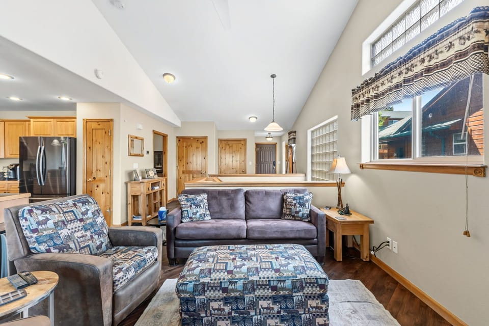 Relax in this bright, open living space with vaulted ceilings and cozy seating—your perfect retreat after a day of adventure, with mountain views framed in the windows.