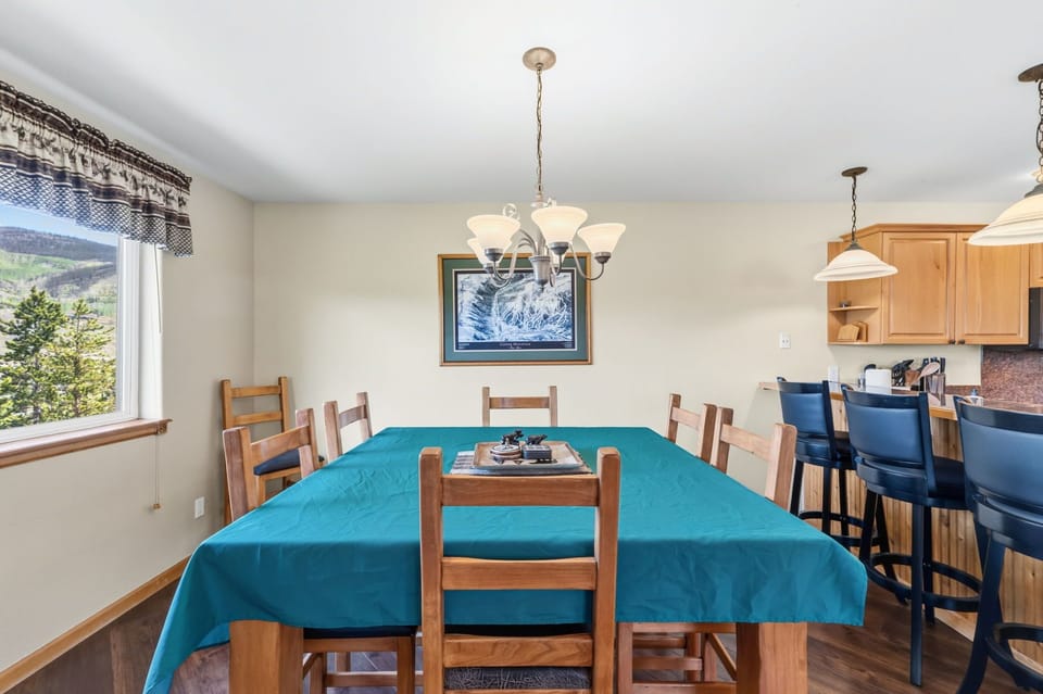 Gather with your group around this spacious dining table, where mountain views frame every meal and the open layout flows seamlessly into the kitchen for easy entertaining.