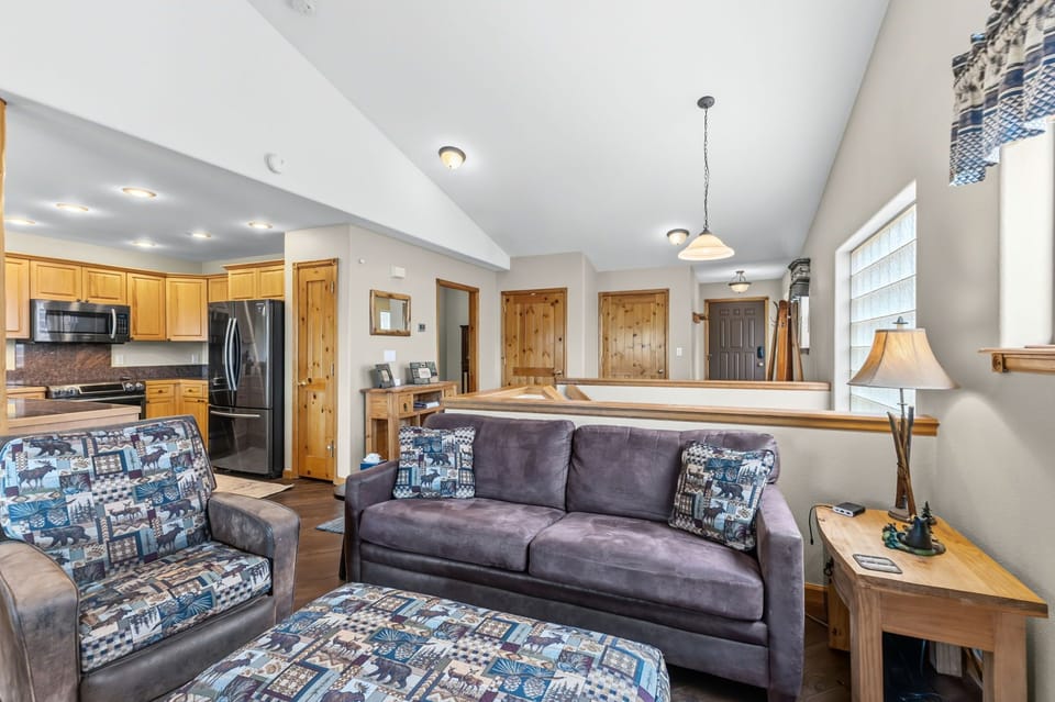 Settle into plush seating where your open-concept space invites relaxation, with a fully equipped kitchen just steps away and warm wood accents throughout your retreat.