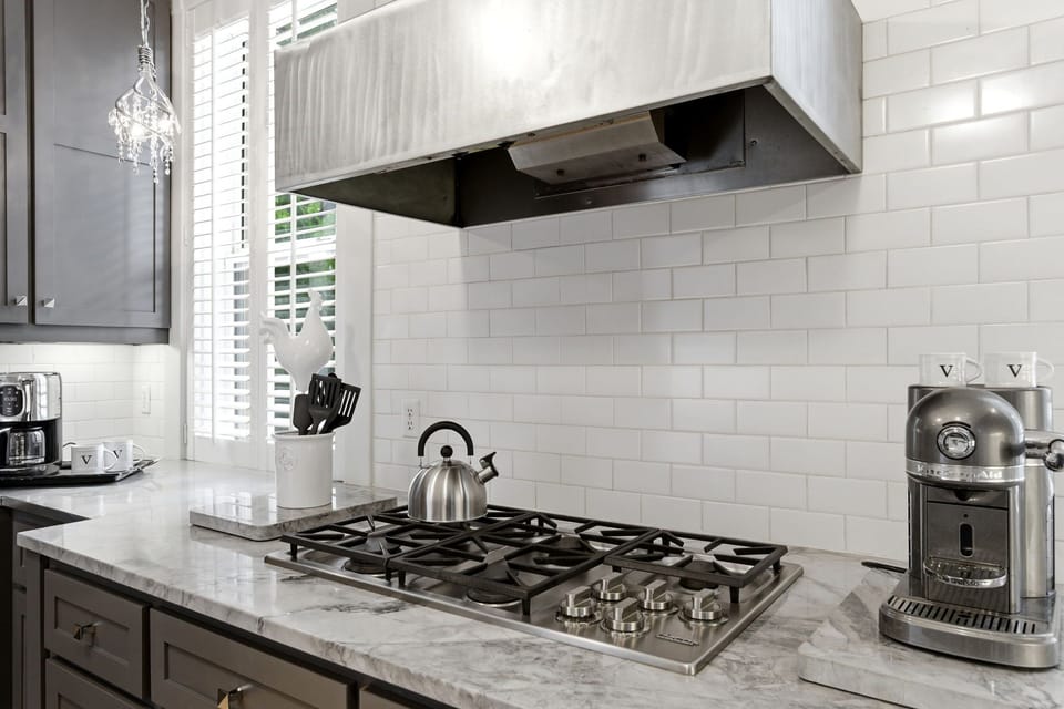 Your sleek gourmet kitchen features stainless steel appliances, a gas range with professional hood, and gleaming marble countertops—perfect for preparing memorable vacation meals.