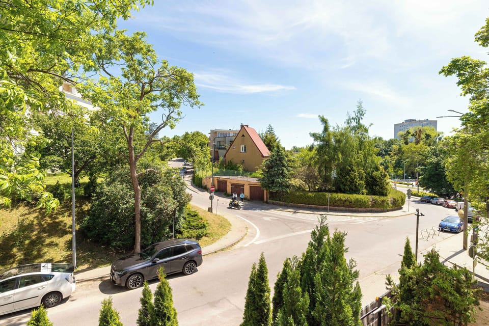 A wider outdoor perspective captures roads, trees, and houses extending into the distance. The scene combines residential buildings with landscaped areas.