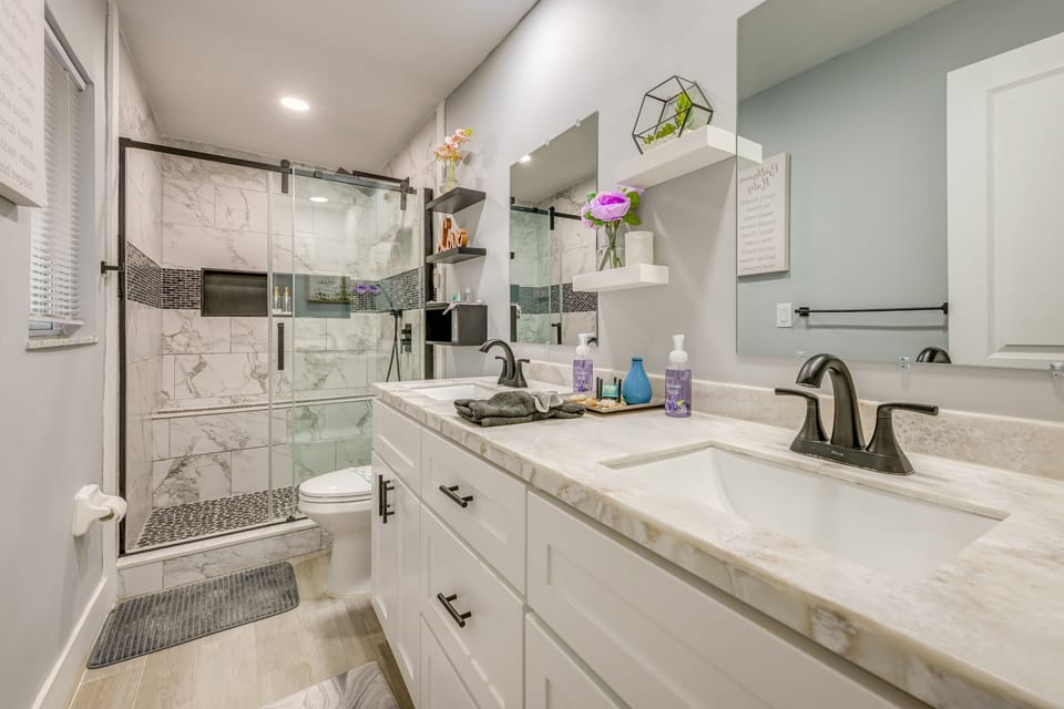 Contemporary bathroom featuring a double vanity and a marble-tile walk-in shower.