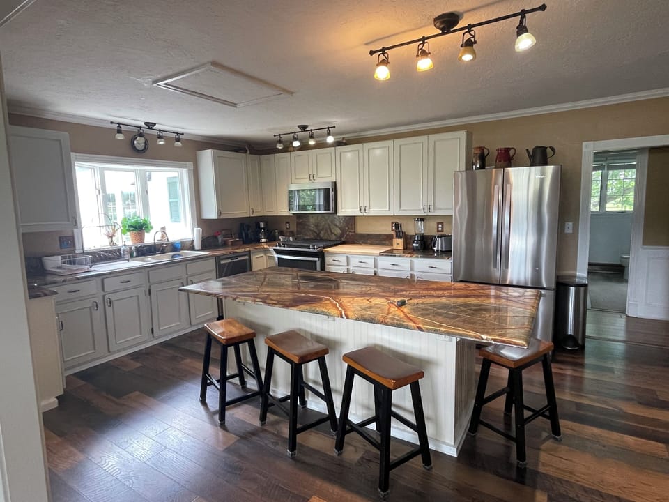 Kitchen with 4 bar stools, gas stove and ample fridge space