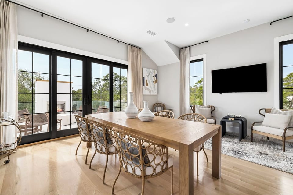 Gather around the sleek dining table or relax in the lounge area, where natural light pours through floor-to-ceiling windows, framing your private balcony and peaceful treetop views.
