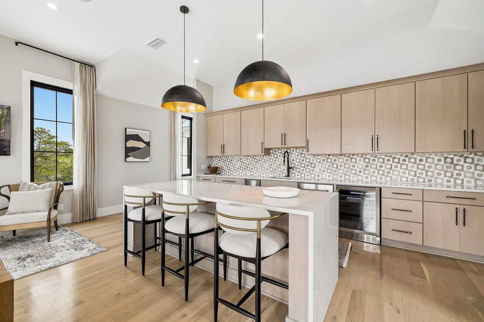 Gather around your island to cook and connect, where modern design meets warm elegance. Natural light floods your open kitchen, highlighting chic pendant lighting and stylish finishes.