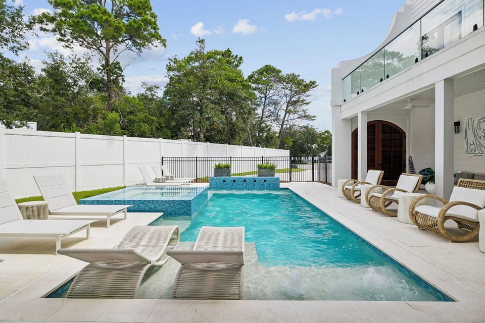 Step into your own private oasis—a sparkling pool with built-in loungers and a bubbling hot tub, all framed by lush greenery and shaded by towering pines. Perfect for unwinding under the sun or stars.