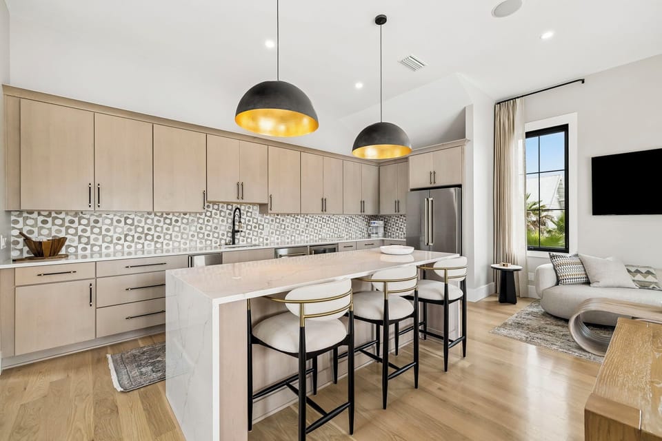 Step into your open-plan sanctuary where a sleek kitchen flows into a bright living space. Stylish pendant lights cast a warm glow over a chic island—perfect for your morning coffee or evening wind-down.