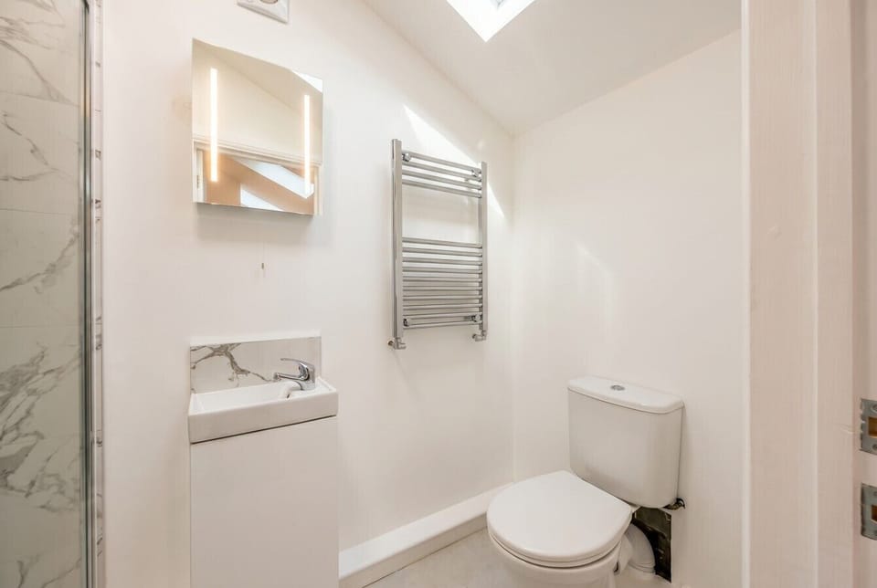 Sleek en suite with marble basin and a heated towel rail