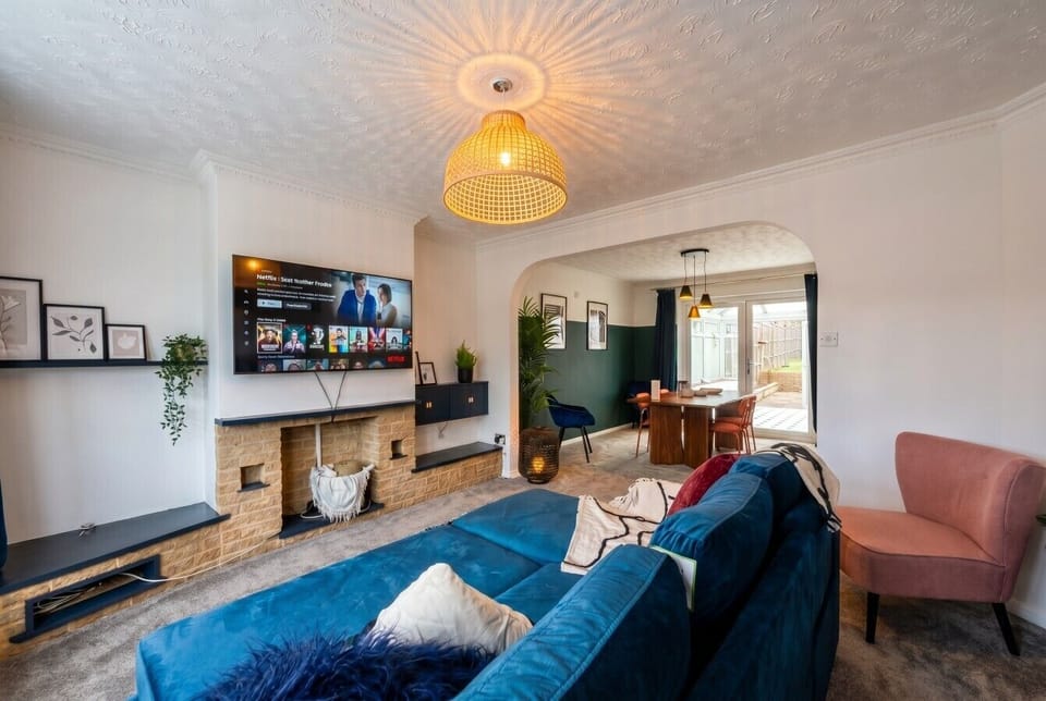 Cosy fireside lounge flows into a stylish dining zone, TV ready for movie nights.