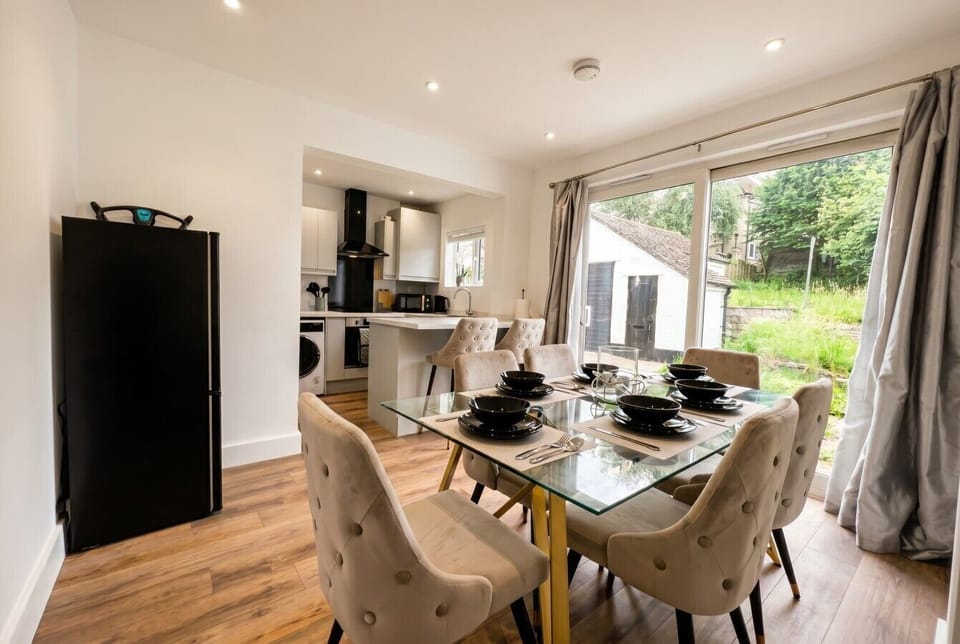 Open-plan kitchen diner seats six with leafy garden views through patio doors.