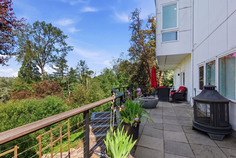 Private tree-lined terrace with lounge seating and outdoor fireplace