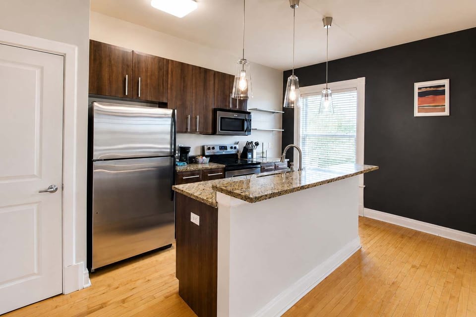 Full kitchen — stainless fridge, granite island, and dishwasher