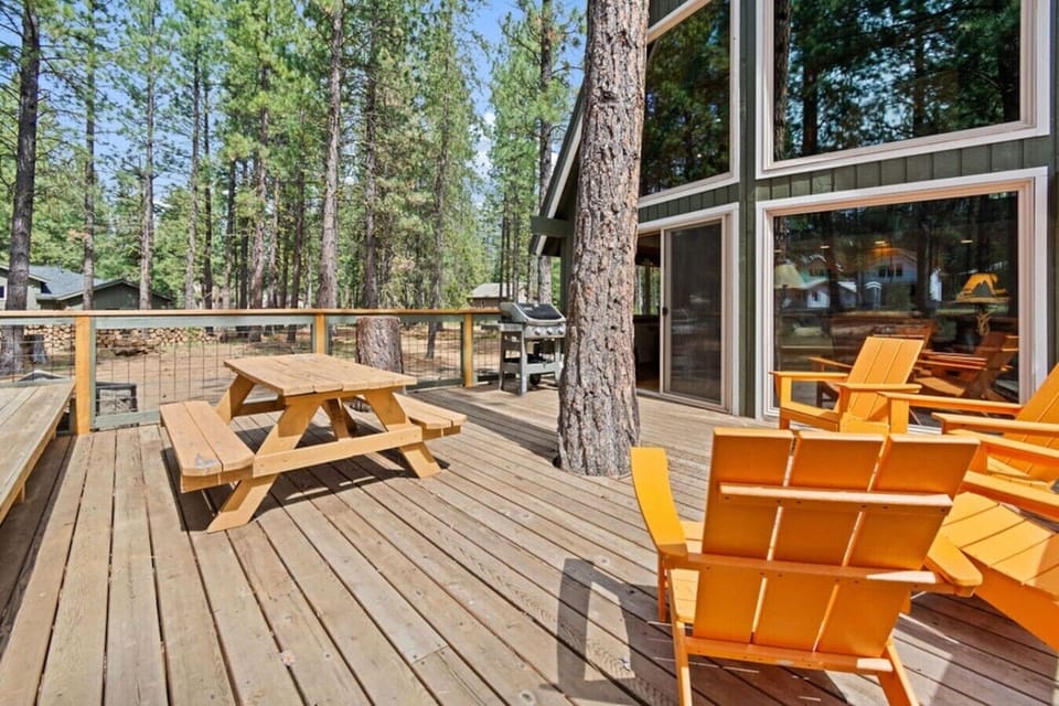 Private A-frame retreat surrounded by towering pines and a spacious deck.