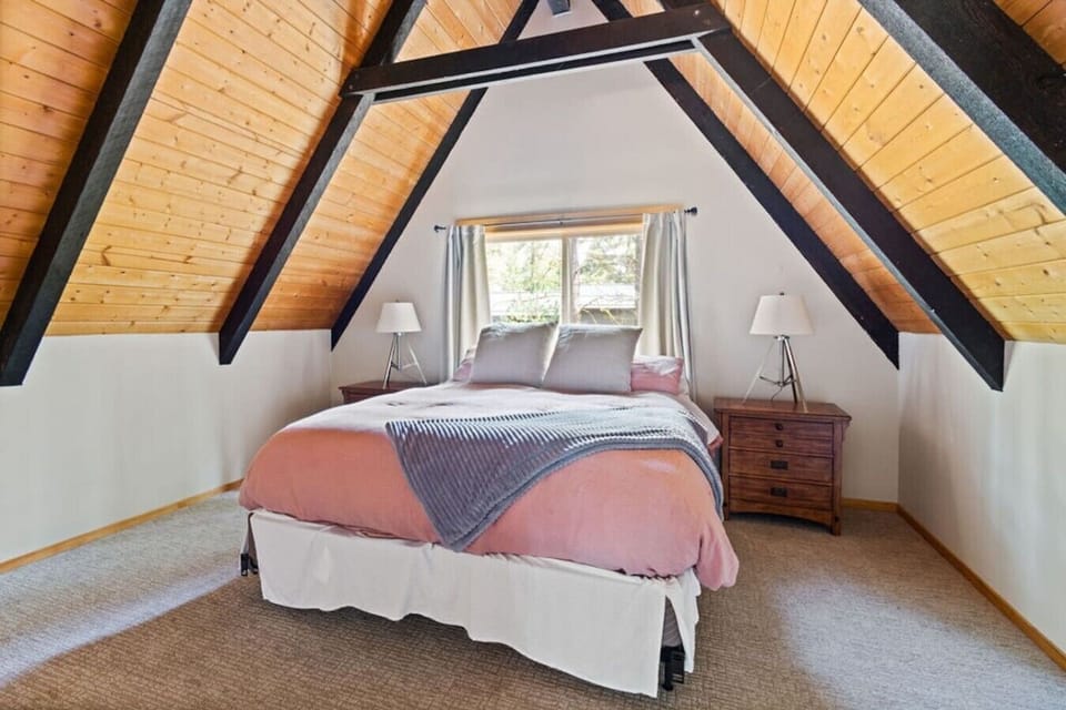 Comfortable upstairs king retreat beneath classic A-frame ceilings.