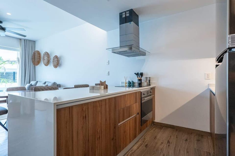 Fully equipped kitchen with cooktop, range hood and wood cabinetry