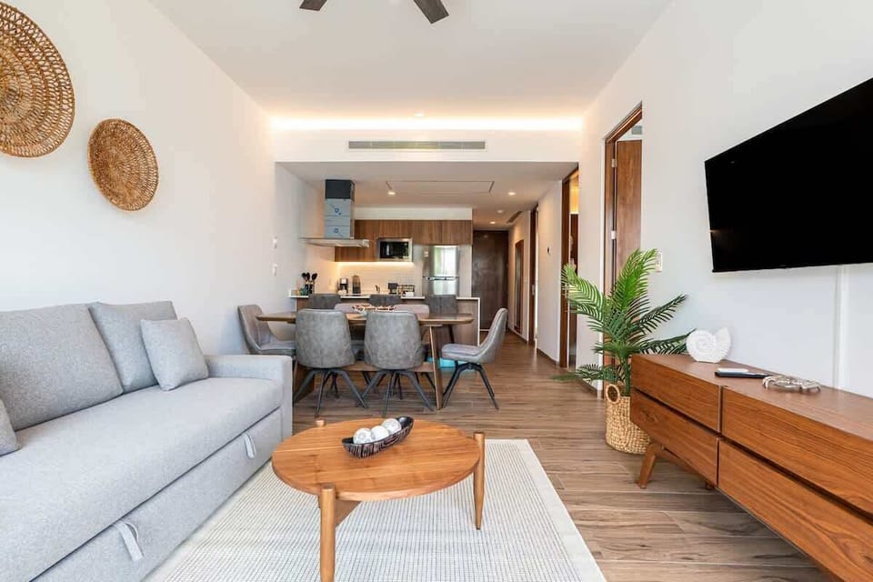 Comfortable living room with smart TV, ceiling fan and plants