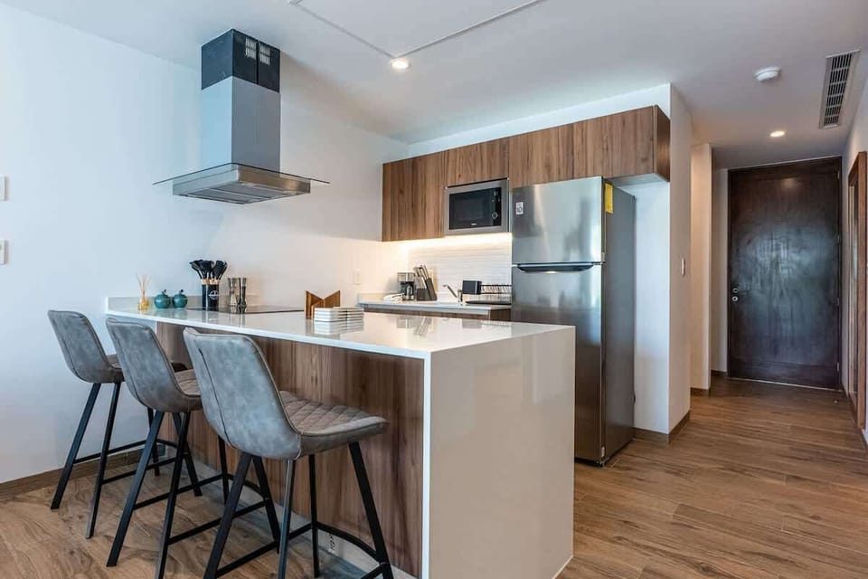 Kitchen breakfast bar with stools and stainless refrigerator