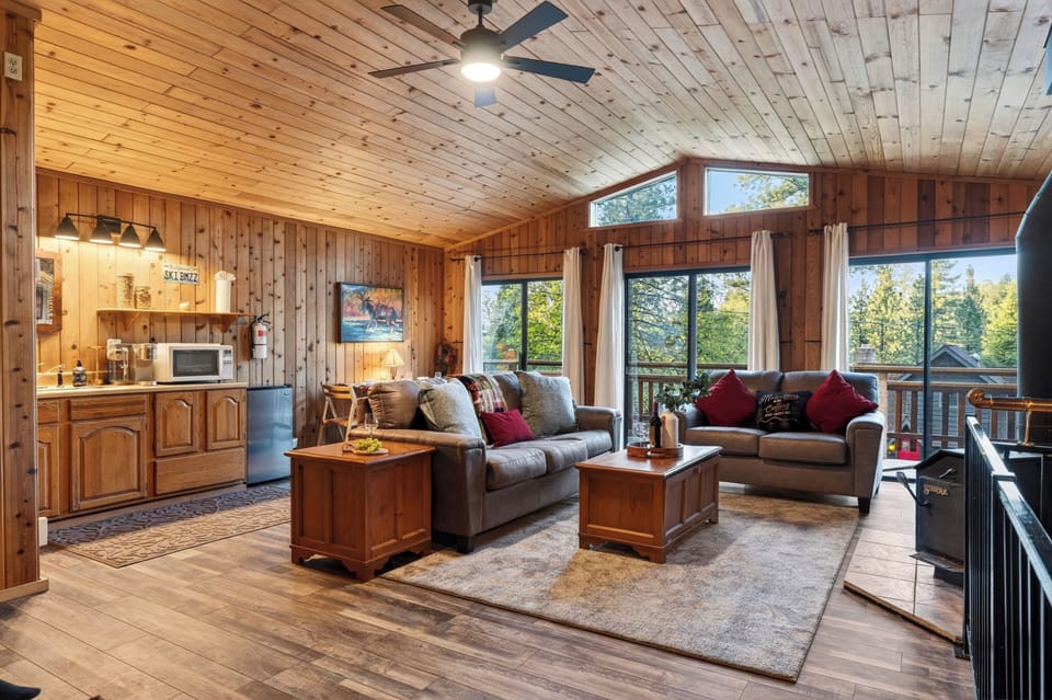 A grand view of the upper-level living area highlights the generous proportions and vaulted wood ceilings.