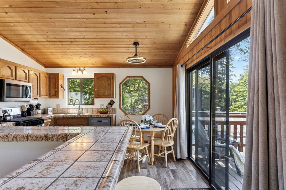 An expansive breakfast bar connects the kitchen to the dining and outdoor areas, complete with sliding glass doors leading to the deck.