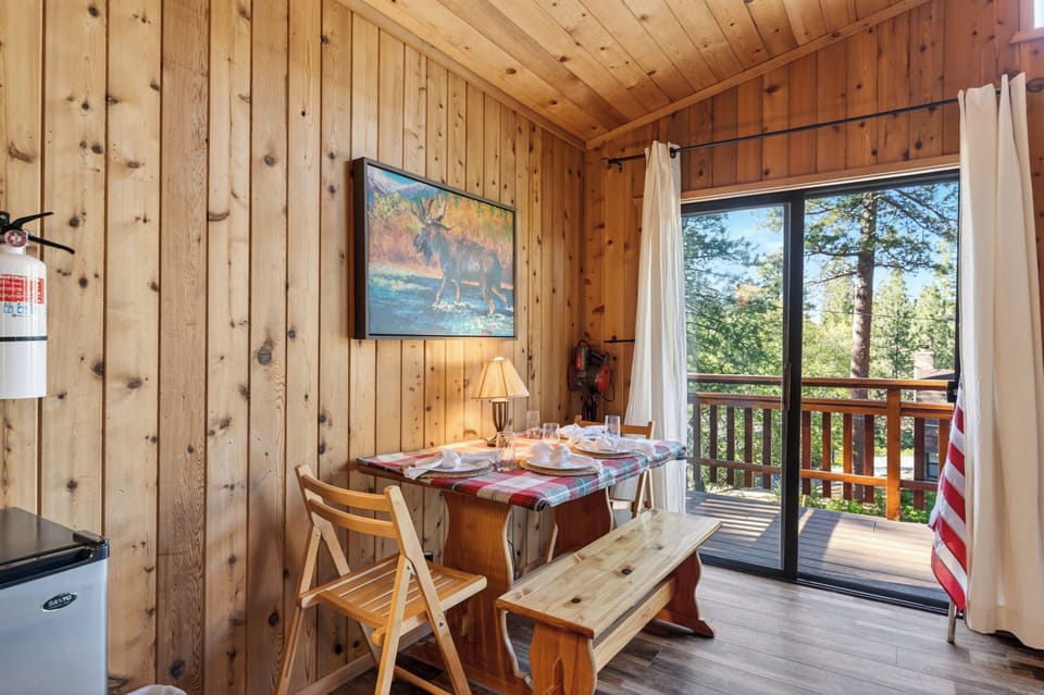 An intimate dining nook nestled against the wood-paneled walls with direct access to a scenic outdoor balcony.