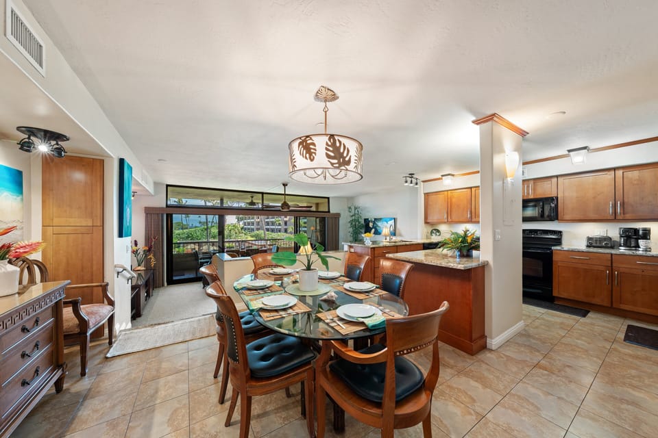 Enjoy dinner at the elegant glass-top dining table where open sightlines look out toward the living area and scenic outdoor views.