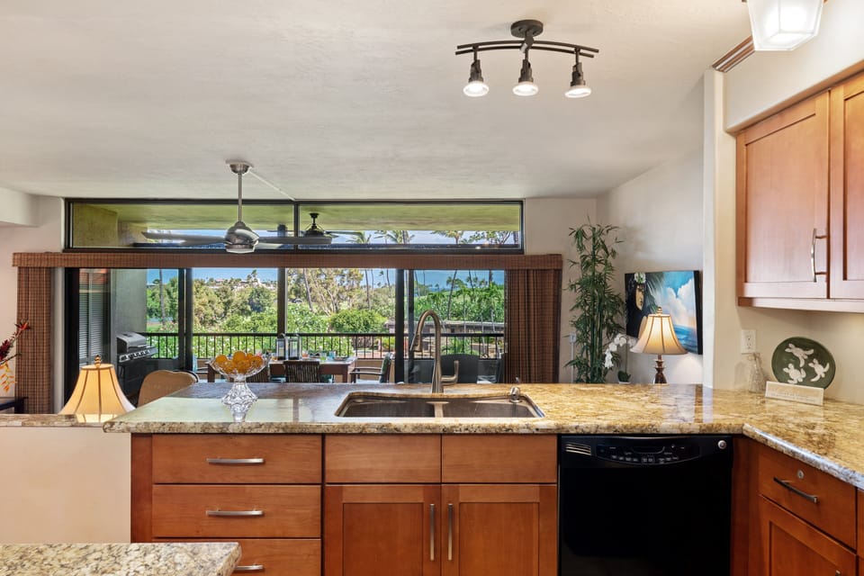 The wide kitchen pass-through offers convenient under-counter storage and looks straight out toward the bright dining and living areas.