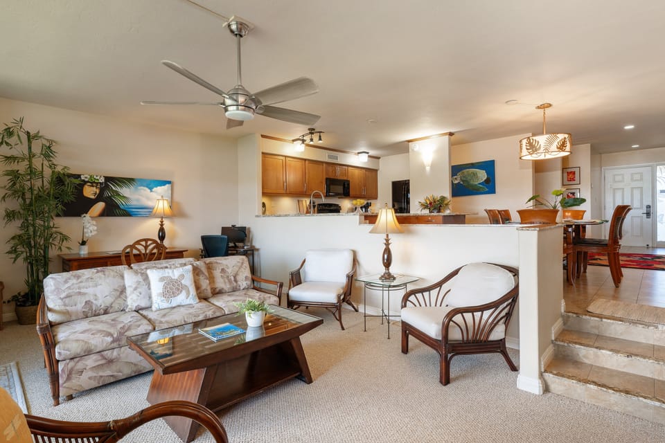 Relax in the split-level living area where comfortable, tropical-print sofas offer a cozy space to gather after a day at the beach.