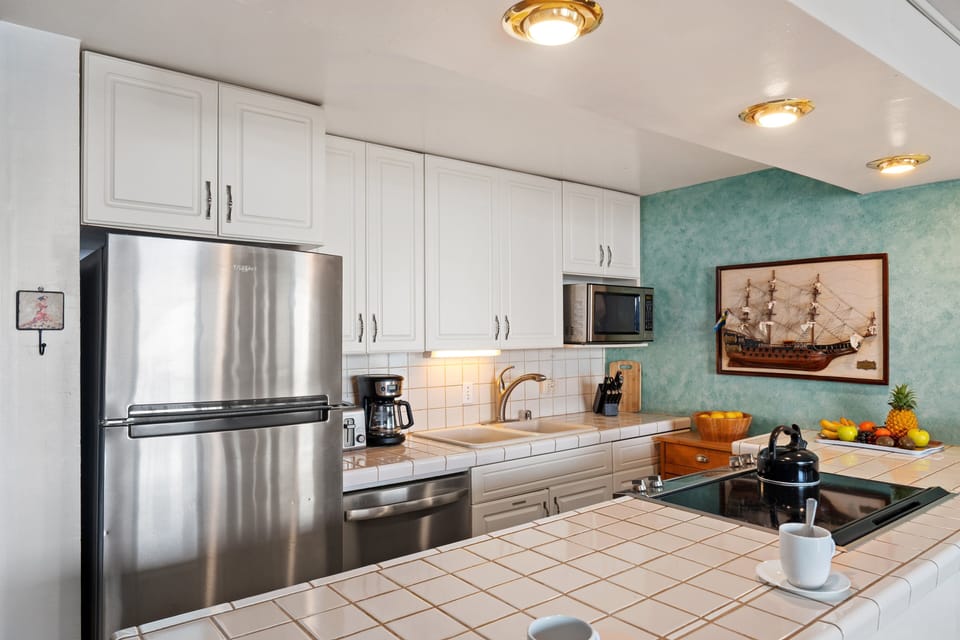 Fully equipped kitchen with stainless steel appliances and spacious counter seating.