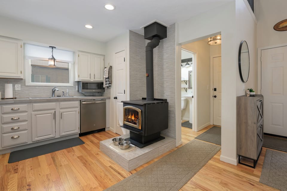 1126 Wester Road offers a spot to gather in your open-concept kitchen and living area where the cozy fireplace creates perfect ambiance for cooking and relaxing together.