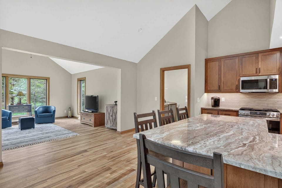 Step into this airy open-concept retreat where soaring ceilings and natural light create your perfect mountain escape. Gather around the spacious granite island for morning coffee while you plan your adventures.