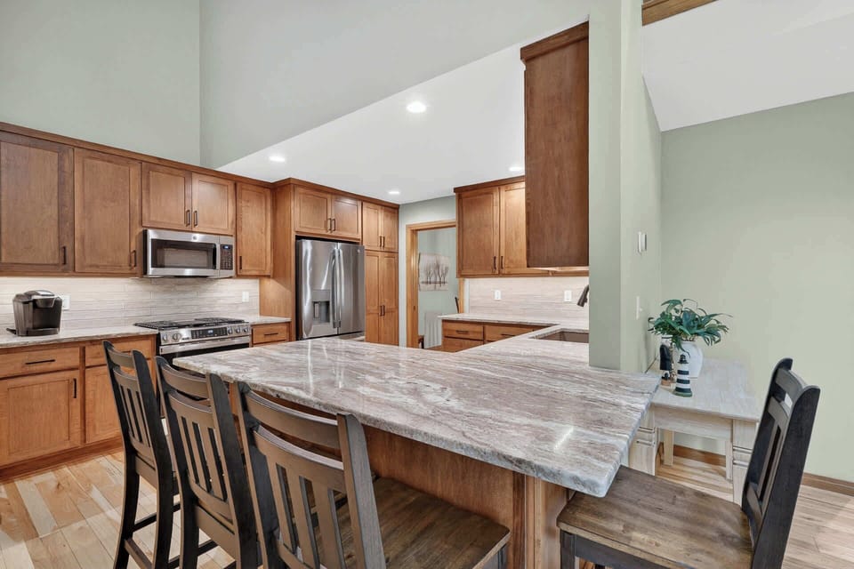 Step into your vacation kitchen where gleaming marble countertops and warm wood cabinetry invite you to gather around the spacious island for morning coffee or evening meals with loved ones.