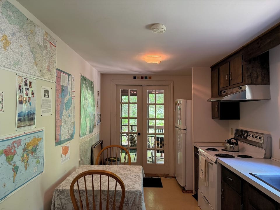This inviting kitchen features full-size appliances and a cozy dining table, with maps on the walls adding character and charm. The French doors open to your private balcony, letting natural light brighten your meal prep and dining moments.
