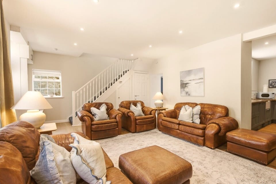 Spacious lounge with leather seating and open-plan layout.