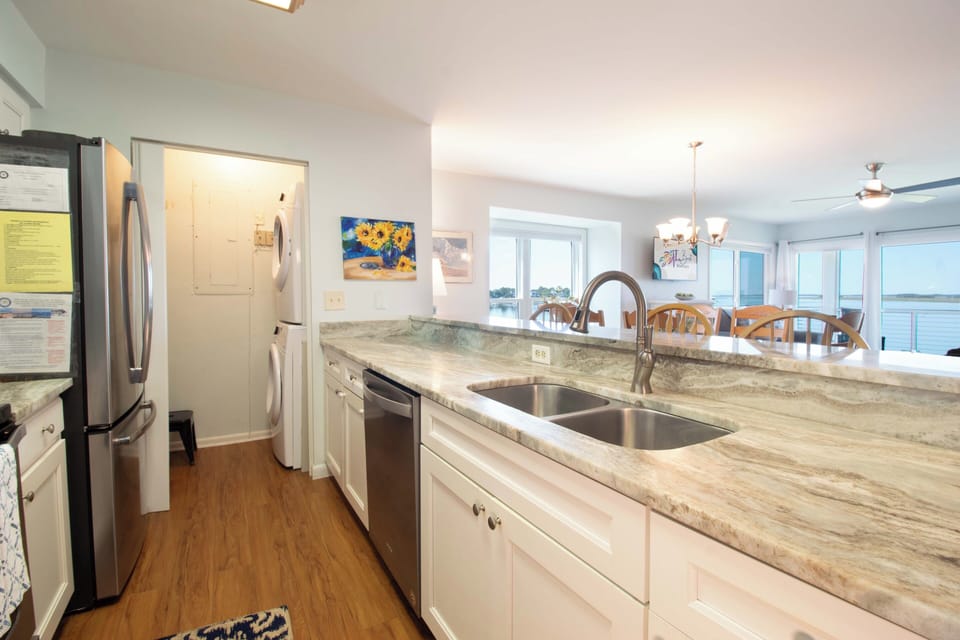 You'll love preparing meals in this bright, modern kitchen with sleek granite counters and stainless appliances while enjoying stunning water views through the dining area windows.