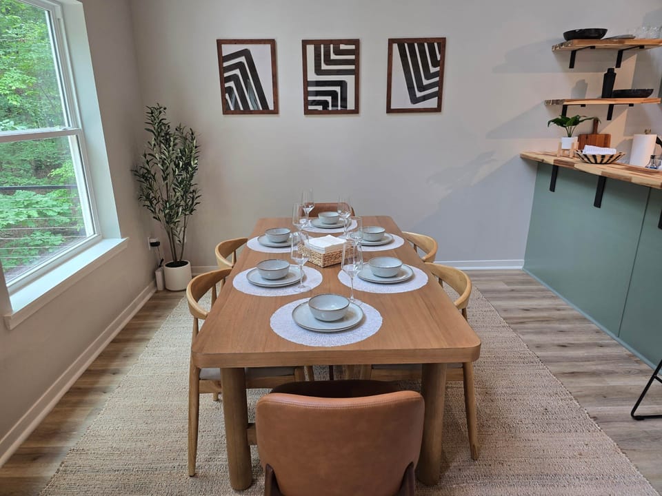 Dining room with a view of the wooded landscape behind the home.