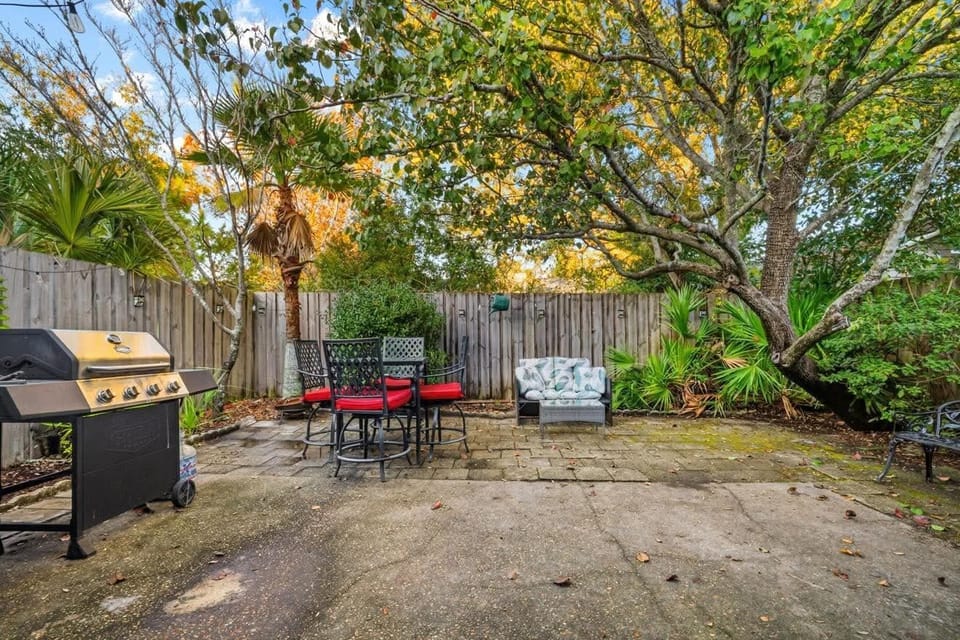 Private fenced patio with seating and grill