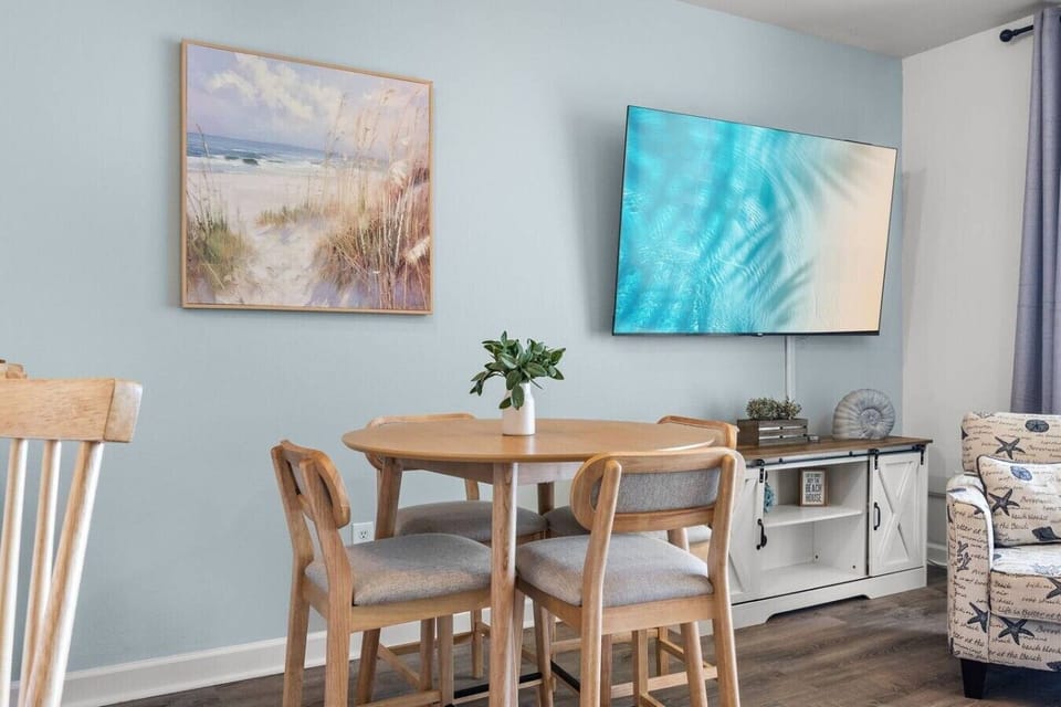 The dining area and large TV create the perfect space to enjoy meals, movie nights, and time together after the beach.