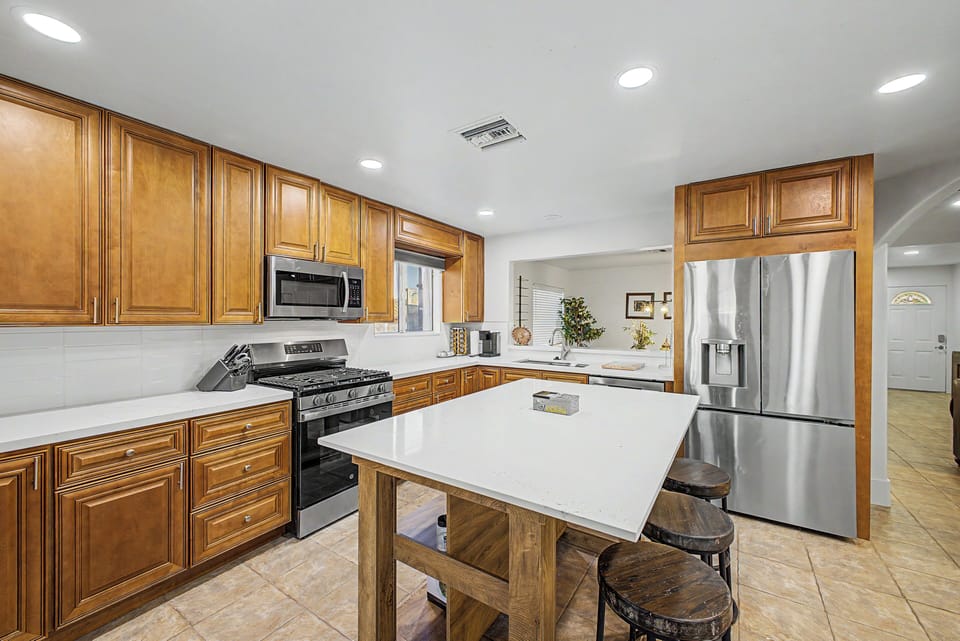 Chef's kitchen with high end cabinets, appliances, island and quartz countertops