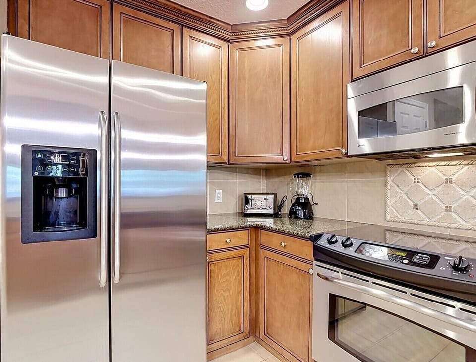 Fully equipped kitchen featuring stainless steel appliances, granite countertops, and ample cabinet space.