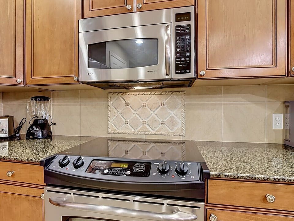 Modern kitchen featuring stainless steel appliances, granite countertops, and ample workspace.