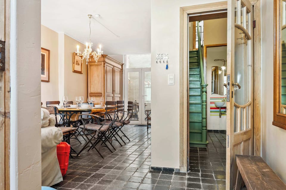 Welcoming entrance hall with a key station, original tiled floor and a glimpse of the signature green staircase. Step inside our beautifully renovated townhouse in the historic heart of Bruges.