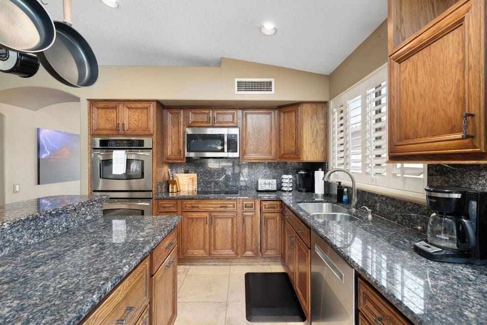 Double wall ovens and a built-in microwave make this kitchen ready for any meal, big or small, with rich wood cabinetry and striking granite throughout.